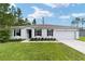 Single-story house with a two-car garage and landscaped front yard at 781 Marion Oaks Trl, Ocala, FL 34473