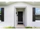 Modern home exterior featuring a black front door and black shutters at 781 Marion Oaks Trl, Ocala, FL 34473
