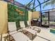 Relaxing patio with lounge chairs, a green wall, and a Hakuna Matata sign at 4791 Terrasonesta Dr, Davenport, FL 33837