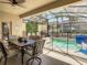 Enclosed patio area with dining table and pool access at 4791 Terrasonesta Dr, Davenport, FL 33837