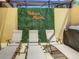 Three lounge chairs on a patio with a green wall and Hakuna Matata sign at 4791 Terrasonesta Dr, Davenport, FL 33837