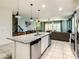 Open concept kitchen with island, stainless steel appliances, and granite countertops at 4791 Terrasonesta Dr, Davenport, FL 33837