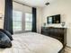 Bright bedroom with a dresser, TV, and comfortable bed at 4791 Terrasonesta Dr, Davenport, FL 33837
