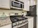 Stainless steel gas range with microwave above in modern kitchen at 4791 Terrasonesta Dr, Davenport, FL 33837