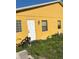 Yellow house exterior with a white door and small windows at 709 N Disston, Tavares, FL 32778