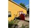 Yellow house exterior with a red gate and garden tools at 709 N Disston, Tavares, FL 32778