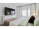 Bright bedroom with king bed, large TV, dresser, and neutral decor at 6165 Carrier Dr # 1206, Orlando, FL 32819