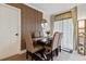 Bright dining room with modern table and chairs, wood wall accents, and access to a balcony at 6165 Carrier Dr # 1206, Orlando, FL 32819