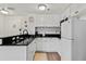White kitchen with black countertops and modern appliances at 6165 Carrier Dr # 1206, Orlando, FL 32819