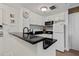 White kitchen with black countertops and modern appliances at 6165 Carrier Dr # 1206, Orlando, FL 32819