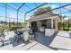 Outdoor kitchen with grill, refrigerator, and bar seating at 1306 Sweetwater Club Blvd, Longwood, FL 32779