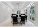 Bright dining room with a glass-top table, black chairs, and large windows at 1306 Sweetwater Club Blvd, Longwood, FL 32779