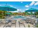 Community pool with lounge chairs, tables, and blue umbrellas, offering a refreshing retreat at 4114 Breakview Dr # 406, Orlando, FL 32819