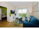 Bright living room with a blue sofa, balcony access, and hardwood floors at 4114 Breakview Dr # 406, Orlando, FL 32819