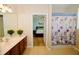 Bathroom with a shower/tub combo, double vanity, and view of bedroom at 4114 Breakview Dr # 406, Orlando, FL 32819