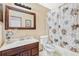 Bathroom with dark brown vanity, floral shower curtain, and toilet at 5920 Norvale Ct, Orlando, FL 32808