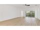 Spacious living room with light wood floors and sliding glass doors at 316 Shelbourne Loop, Kissimmee, FL 34759