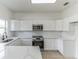 Modern kitchen with white cabinets and quartz countertops at 316 Shelbourne Loop, Kissimmee, FL 34759