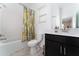 Clean bathroom with dark vanity, shower/tub combo, and grey tile at 1839 Good Neighbor Loop, Kissimmee, FL 34744