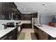 Modern kitchen with dark cabinets, stainless steel appliances, and a large island at 1839 Good Neighbor Loop, Kissimmee, FL 34744