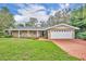 Single story home with brick driveway and rocking chairs on the porch at 279 Rippling Ln, Winter Park, FL 32789