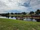 Serene lakefront view with a wooden deck and dock at 4000 Santa Maria Dr # 105, Kissimmee, FL 34741