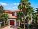 Two-story house with red door and palm trees at 5431 Solterra Cir, Davenport, FL 33837