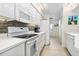 White kitchen with stainless steel appliances and stone backsplash at 4631 S Atlantic Ave # 8301, Ponce Inlet, FL 32127