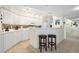 Modern white kitchen featuring a breakfast bar and tile floor at 4631 S Atlantic Ave # 8301, Ponce Inlet, FL 32127