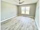 Bright bedroom with ceiling fan, large window, and wood-look floors at 6425 Sw 180Th Cir, Dunnellon, FL 34432