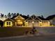 House exterior at night showcasing architectural details and landscaping at 6425 Sw 180Th Cir, Dunnellon, FL 34432