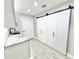 Bright laundry room with white cabinets, granite countertop and barn doors at 6425 Sw 180Th Cir, Dunnellon, FL 34432