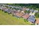 Aerial view showing houses with solar panels, a pool, and a large grassy area at 290 Silver Maple Rd, Groveland, FL 34736