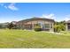 Landscaped backyard showcasing a home with a screened pool and patio at 290 Silver Maple Rd, Groveland, FL 34736