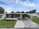 Single-wide manufactured home with carport and screened porch at 411 Palo Verde Dr, Leesburg, FL 34748