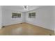 Bright bedroom featuring wood-look floors and two windows at 411 Palo Verde Dr, Leesburg, FL 34748