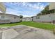 Spacious backyard with grassy area and concrete pad at 411 Palo Verde Dr, Leesburg, FL 34748