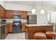 Kitchen with island, stainless steel appliances, and wood cabinets at 12527 Floridays Resort Dr # 312-E, Orlando, FL 32821