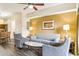 Open living room with gray sofas and chairs, and view of dining area at 12527 Floridays Resort Dr # 312-E, Orlando, FL 32821