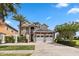 Two-story house with stone and stucco exterior, three-car garage, and landscaping at 1257 Radiant St, Reunion, FL 34747