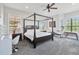 Large bedroom with a four-poster bed, vanity, and plenty of natural light at 1257 Radiant St, Reunion, FL 34747