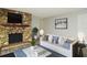 Living room with stone fireplace, comfy couch, and large TV at 213 E Hillcrest St, Altamonte Springs, FL 32701