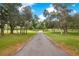 Long paved driveway leading to a charming country home with lush green landscape at 12151 Walker Pond Rd, Winter Garden, FL 34787