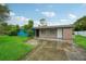 Brick home with blue painted siding, driveway, and grassy yard at 3034 Touraine Ave, Orlando, FL 32812