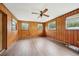Living room with wood paneled walls, wood flooring and ceiling fan at 3034 Touraine Ave, Orlando, FL 32812