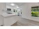 Open concept kitchen with white cabinets, breakfast bar, and grey tile floors at 2620 Osceola Bluff Ln, Geneva, FL 32732