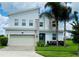 Two story modern home with a large garage and palm trees at 345 Ocean Course Ave, Davenport, FL 33896