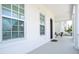 Inviting front porch with columns and seating, welcoming guests to this charming home at 7410 Barrier Cove Way, Kissimmee, FL 34747