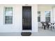 Black front door with sidelights and porch at 7410 Barrier Cove Way, Kissimmee, FL 34747