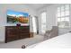 Bedroom with king bed, dresser, large TV, and access to balcony at 7410 Barrier Cove Way, Kissimmee, FL 34747